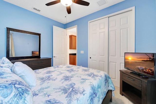 carpeted bedroom featuring ceiling fan and a closet