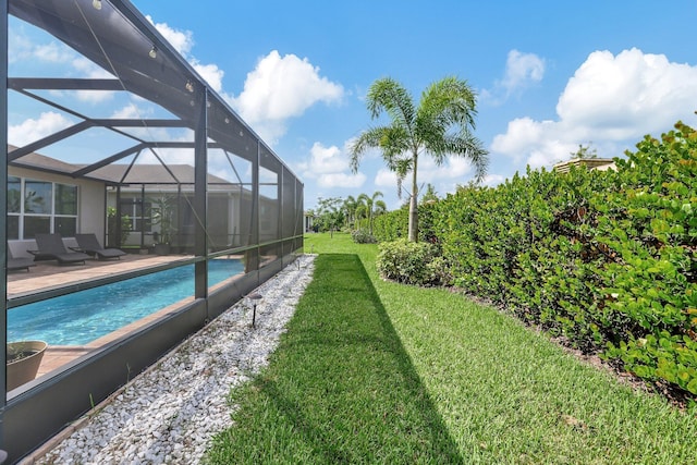 view of swimming pool featuring a patio, a yard, and glass enclosure