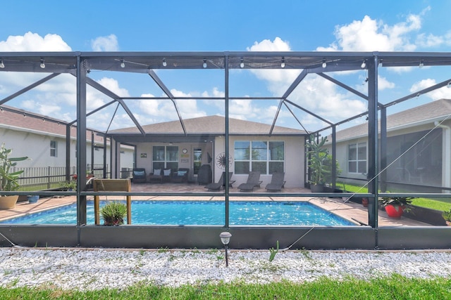 view of pool featuring glass enclosure and a patio area