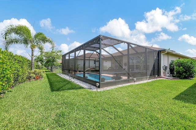 view of swimming pool with a lanai and a lawn