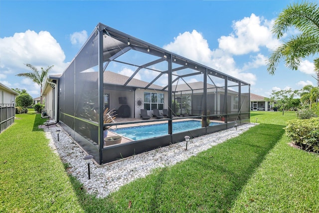 view of swimming pool featuring glass enclosure and a yard