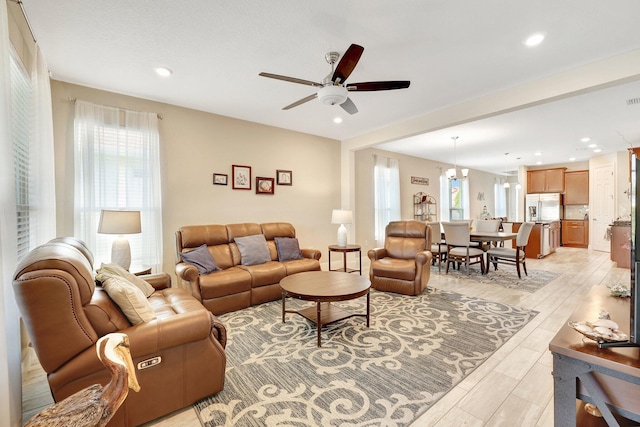 living room with ceiling fan with notable chandelier