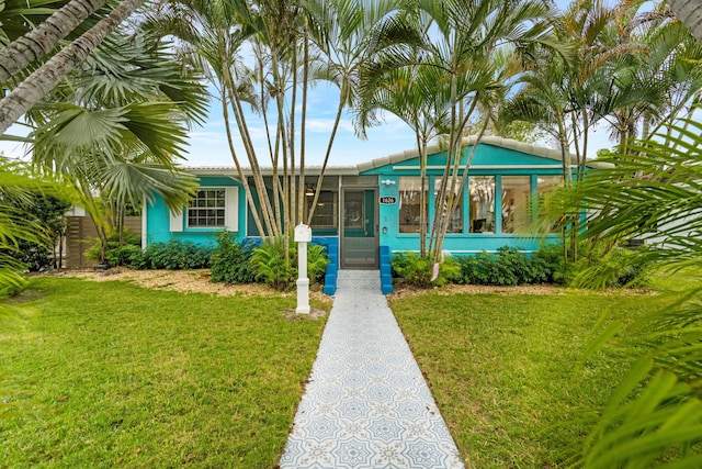 view of front of house featuring a front lawn and a sunroom