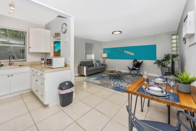 kitchen featuring white cabinets, light tile patterned floors, and sink