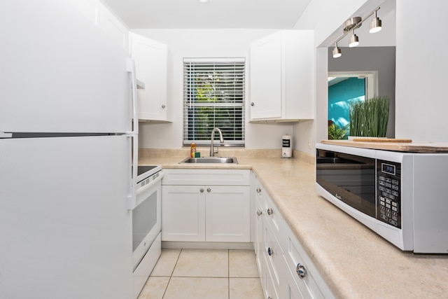 kitchen with sink, white cabinets, white appliances, and light tile patterned floors