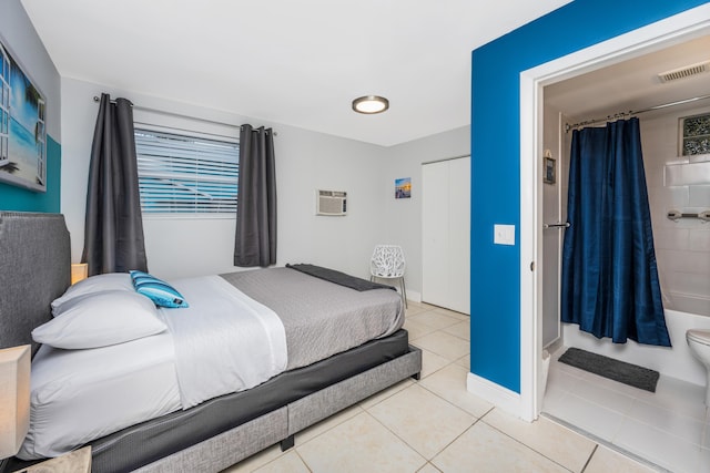 bedroom featuring light tile patterned floors and an AC wall unit