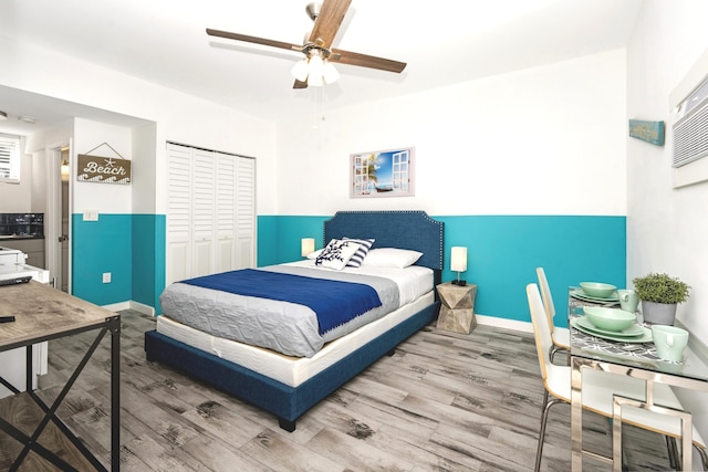 bedroom featuring hardwood / wood-style flooring, ceiling fan, and a closet