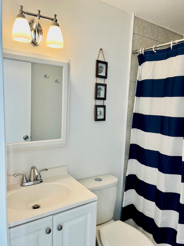 bathroom featuring a shower with shower curtain, vanity, and toilet