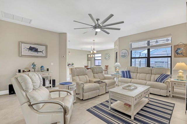 living room with ceiling fan with notable chandelier and light tile patterned floors