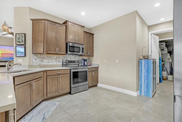 kitchen with sink, light tile patterned flooring, backsplash, and appliances with stainless steel finishes