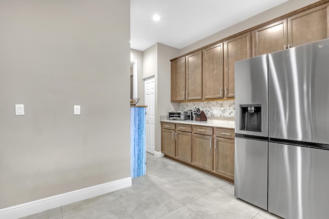 kitchen with light tile patterned floors, tasteful backsplash, and stainless steel fridge with ice dispenser