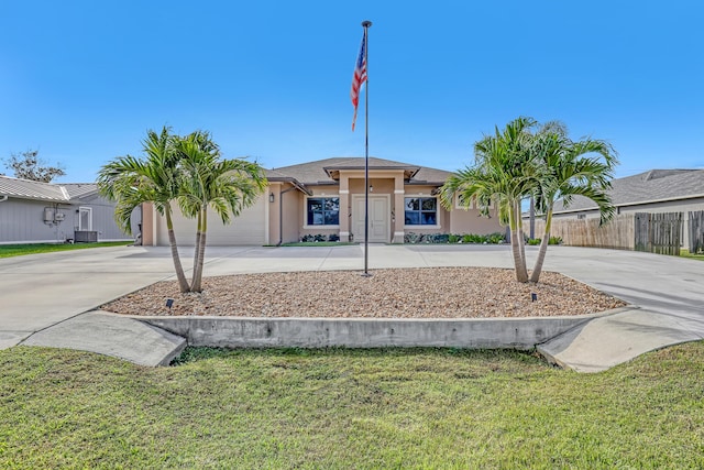 view of front of house with central air condition unit, a front yard, and a garage