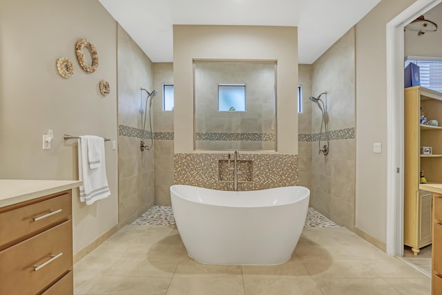 bathroom with tile patterned flooring, independent shower and bath, and vanity