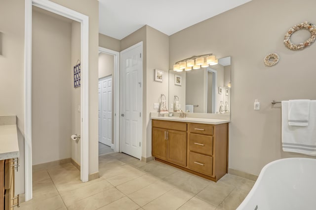 bathroom with a tub, tile patterned flooring, and vanity