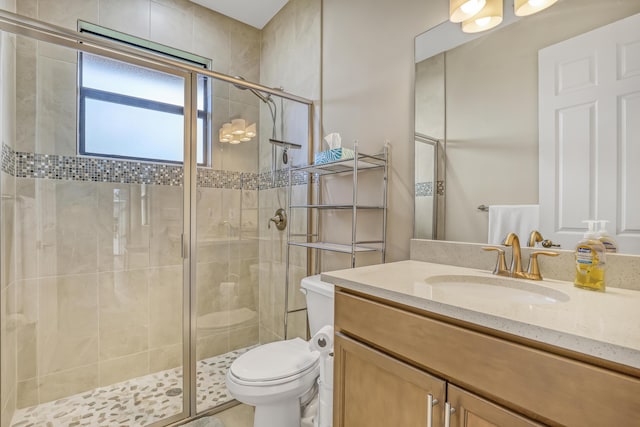 bathroom with toilet, a shower with door, and vanity