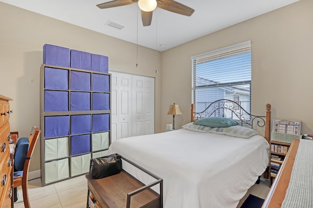 tiled bedroom with ceiling fan and a closet