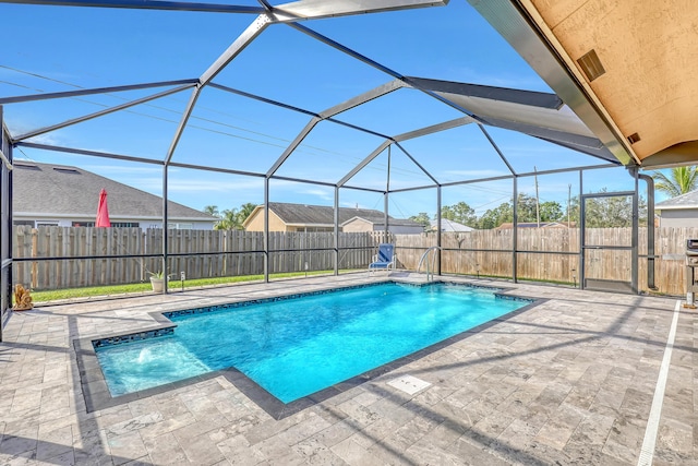 view of pool with glass enclosure and a patio area