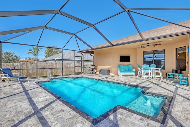 view of swimming pool with a lanai, ceiling fan, and a patio