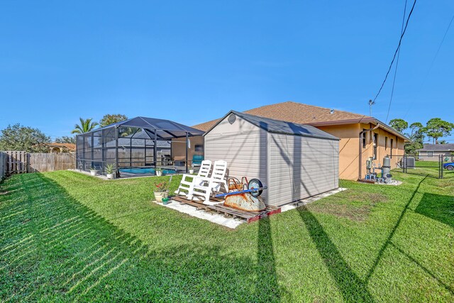 view of yard with a lanai, a storage unit, and a fenced in pool