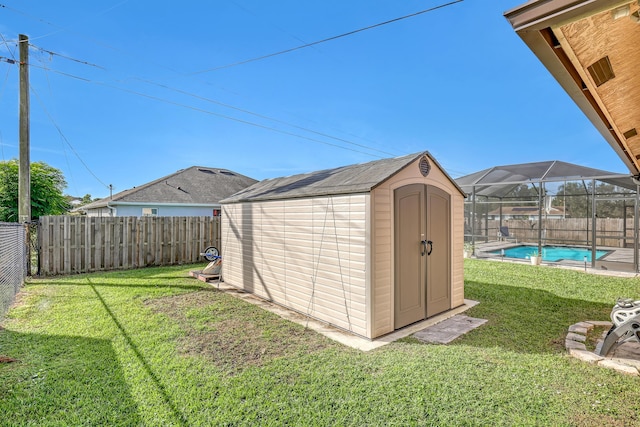 view of outdoor structure featuring a fenced in pool and a lawn