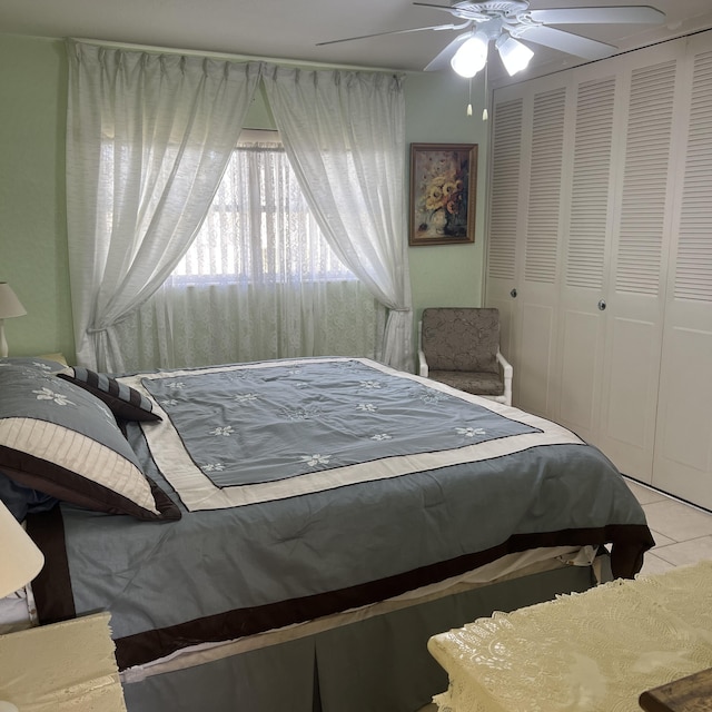 bedroom with tile patterned flooring, ceiling fan, and a closet