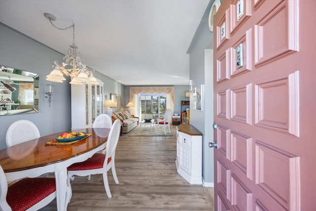 dining area featuring light hardwood / wood-style flooring and a notable chandelier