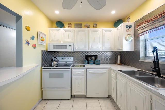 kitchen with sink, light tile patterned floors, backsplash, white appliances, and white cabinets