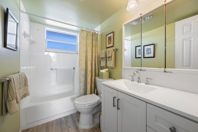 full bathroom featuring hardwood / wood-style flooring, shower / bath combination with curtain, toilet, and vanity