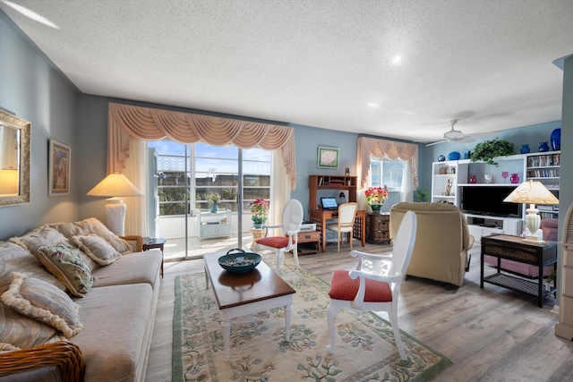 living room with hardwood / wood-style floors, a textured ceiling, and ceiling fan