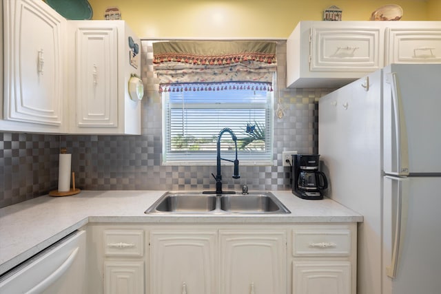 kitchen featuring decorative backsplash, sink, dishwasher, white cabinets, and white fridge