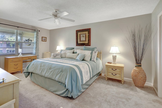 bedroom featuring ceiling fan, light carpet, and a textured ceiling