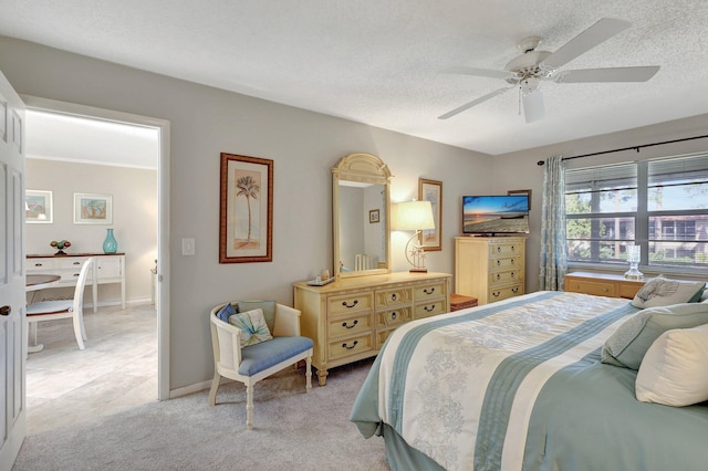 bedroom featuring ceiling fan, light carpet, and a textured ceiling