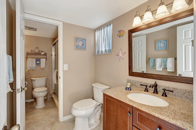 bathroom featuring tile patterned floors, vanity, a shower with shower door, and toilet