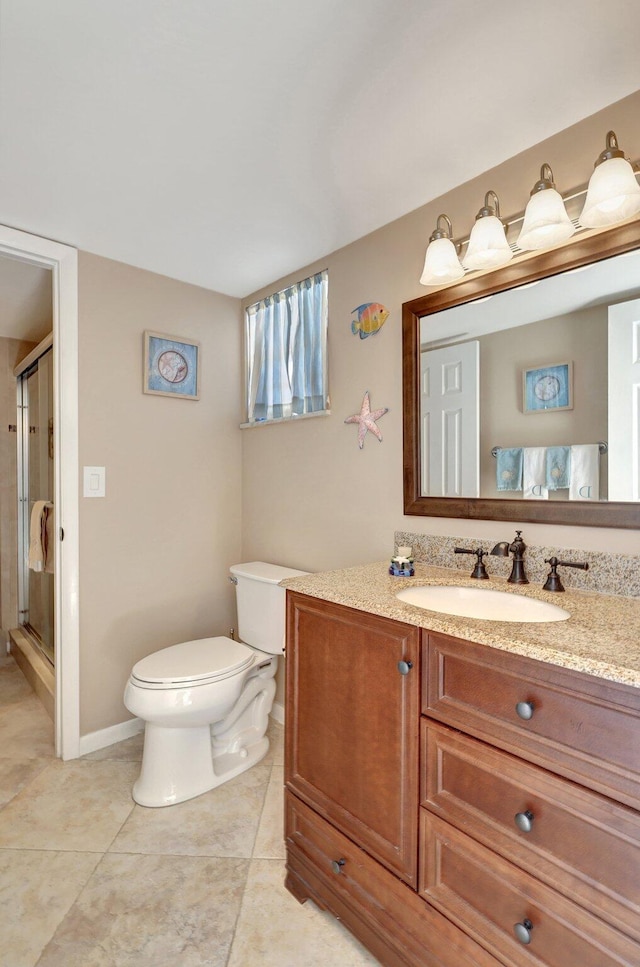 bathroom with tile patterned flooring, vanity, toilet, and a shower with door