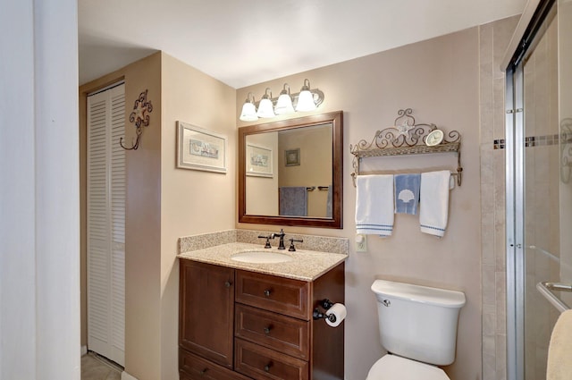 bathroom featuring vanity, a shower with shower door, and toilet