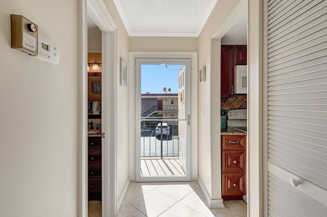 doorway with light tile patterned floors, a textured ceiling, and ornamental molding