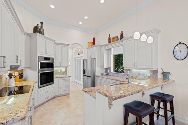 kitchen featuring hanging light fixtures, white cabinets, decorative backsplash, and stainless steel appliances