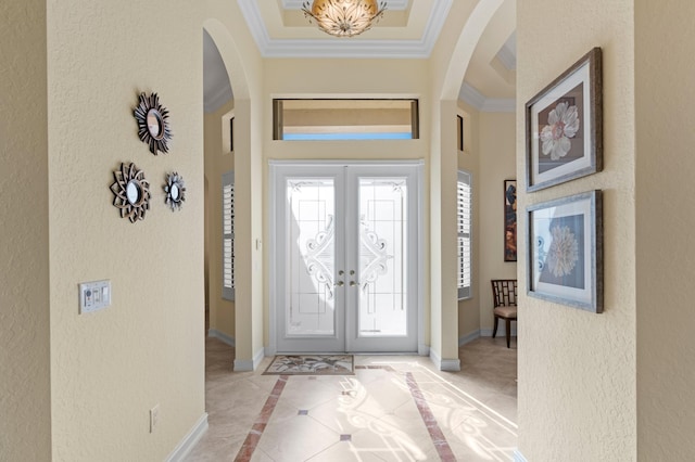 foyer entrance featuring light tile patterned floors, ornamental molding, and french doors