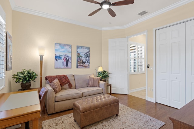 living room with ceiling fan, crown molding, and hardwood / wood-style flooring