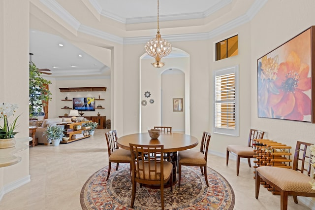 dining room featuring crown molding, ceiling fan with notable chandelier, and a tray ceiling