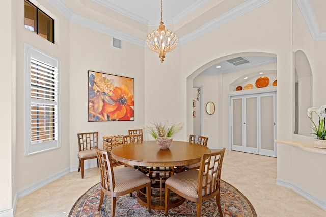 dining room with a high ceiling, an inviting chandelier, crown molding, and a raised ceiling