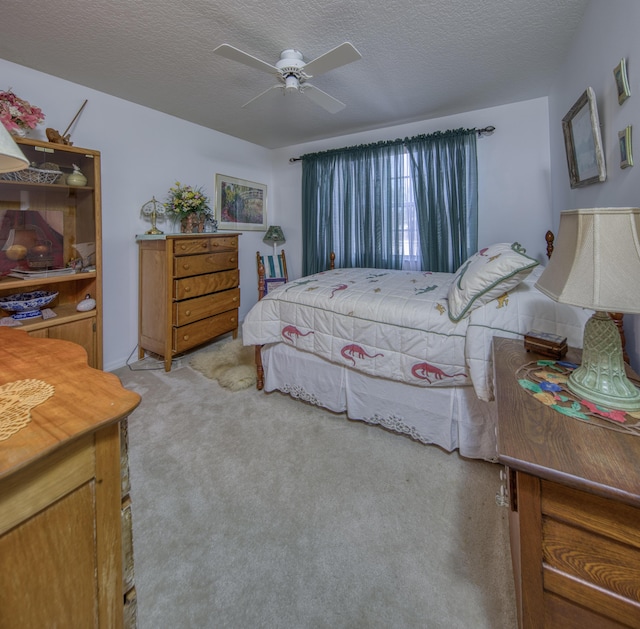 carpeted bedroom with ceiling fan and a textured ceiling