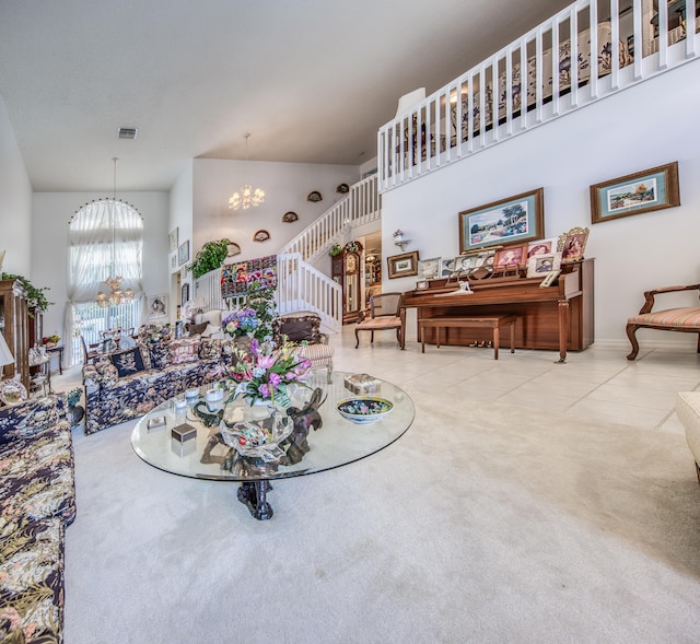 living room with a high ceiling, a notable chandelier, and light tile patterned flooring