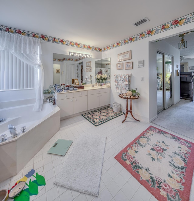 bathroom featuring vanity, tile patterned flooring, and a bathing tub