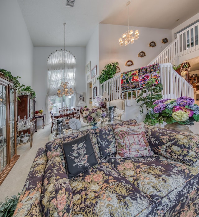 carpeted living room with a high ceiling and an inviting chandelier