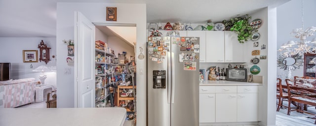 kitchen featuring white cabinets, stainless steel refrigerator with ice dispenser, and a chandelier