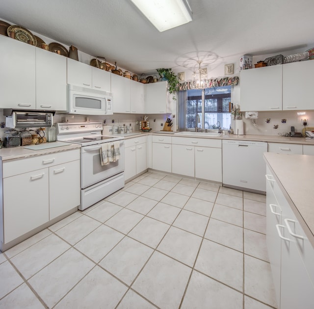 kitchen featuring white cabinetry, sink, white appliances, and light tile patterned floors