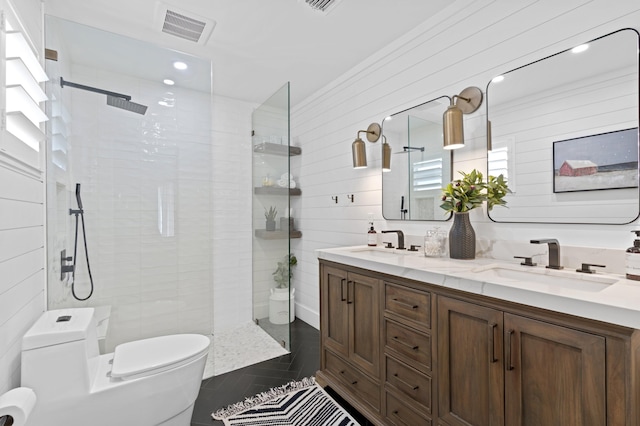 bathroom featuring toilet, wood walls, a tile shower, vanity, and tile patterned flooring