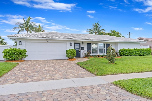 ranch-style house featuring a garage and a front lawn