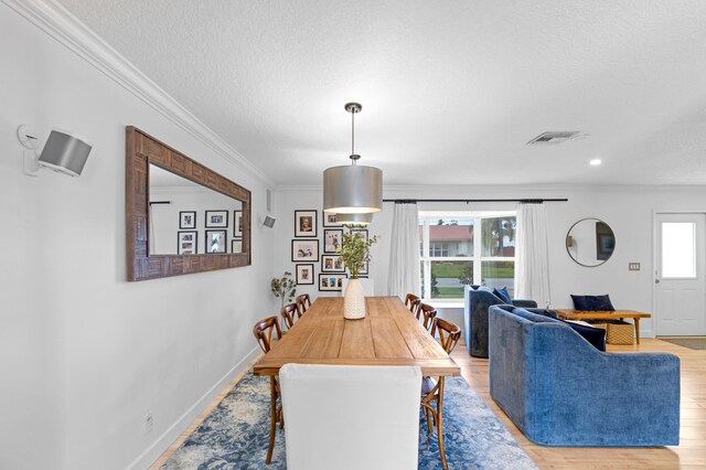 dining room featuring ornamental molding and light hardwood / wood-style flooring